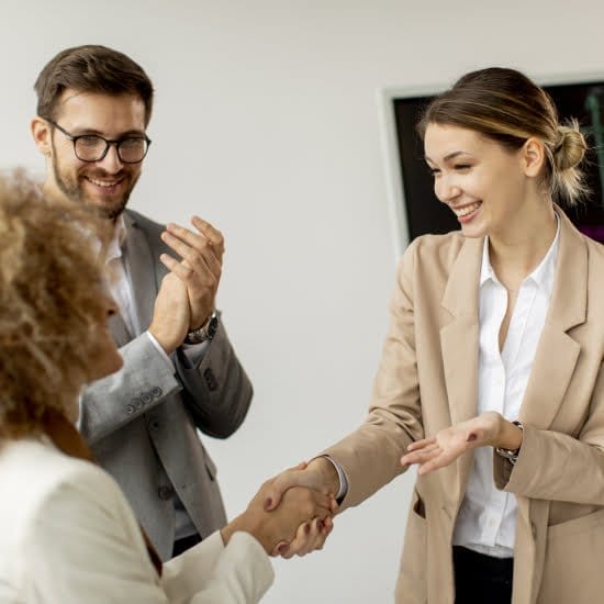 Business professionals shaking hands in a modern office, symbolizing successful collaboration and partnership.