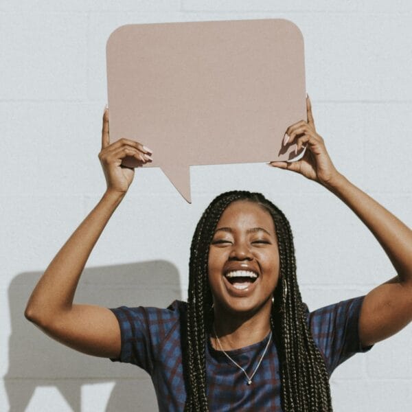 Cheerful black woman showing a blank speech bubble